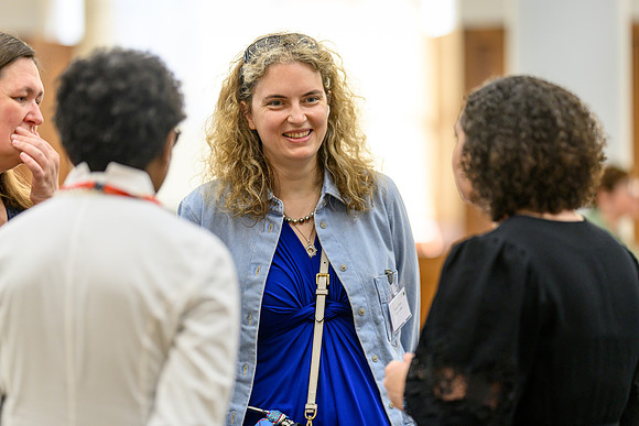Anica smiling in conversation with Katharina, Nicole, and 'Funmi, all attendees gathered in a small group at the summit.