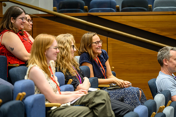 Audience response to Round 3 funding shout-out from Shitij Kapur – Roxanne Keynejad looking pleased – with Rachel Gibson (Root To Tip) smiling next to her & Elena, Rhiannon and Sarah Trepiccione (NMES